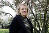 A photograph of Annie Ernaux in front of a tree