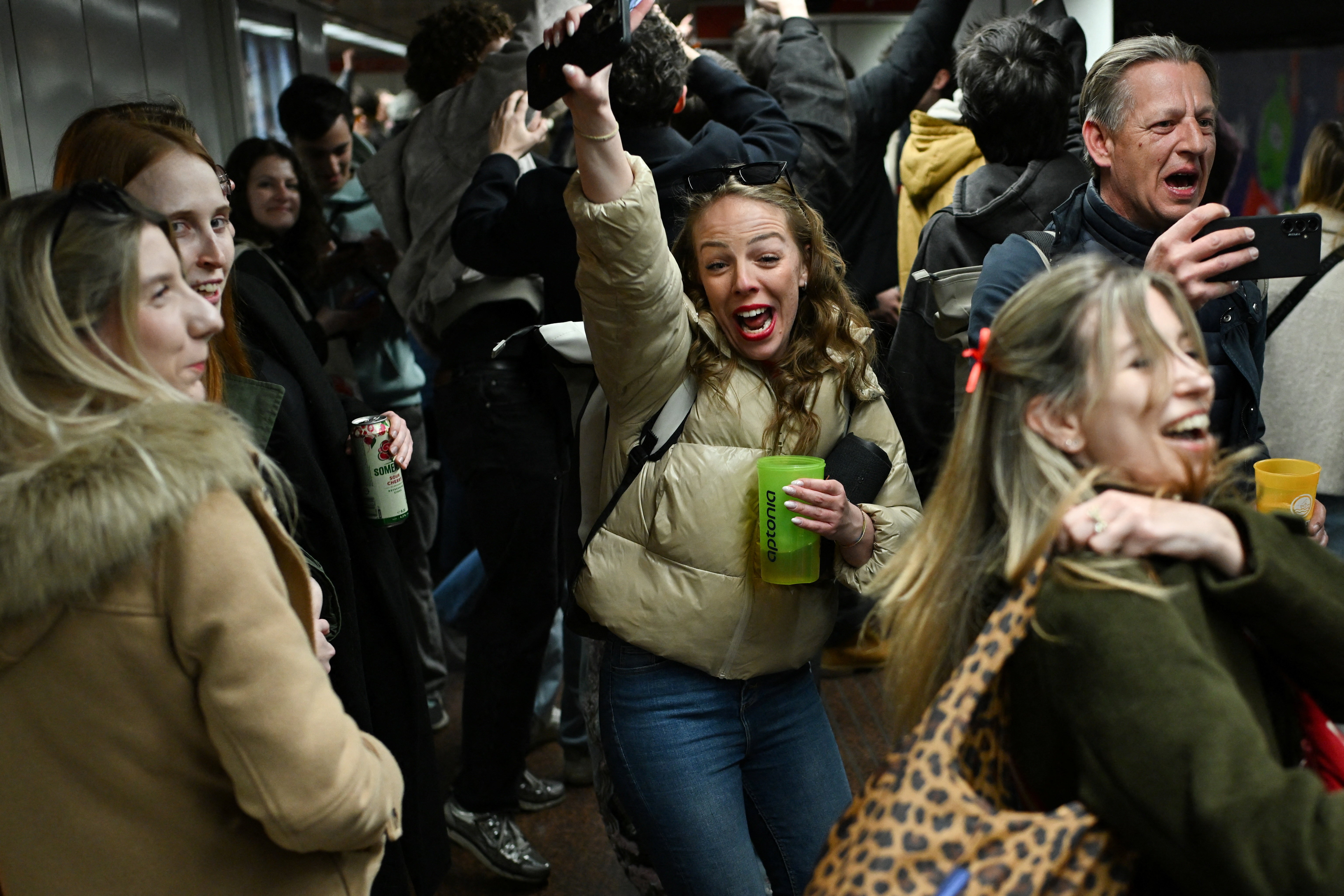 People celebrate in a metro station.