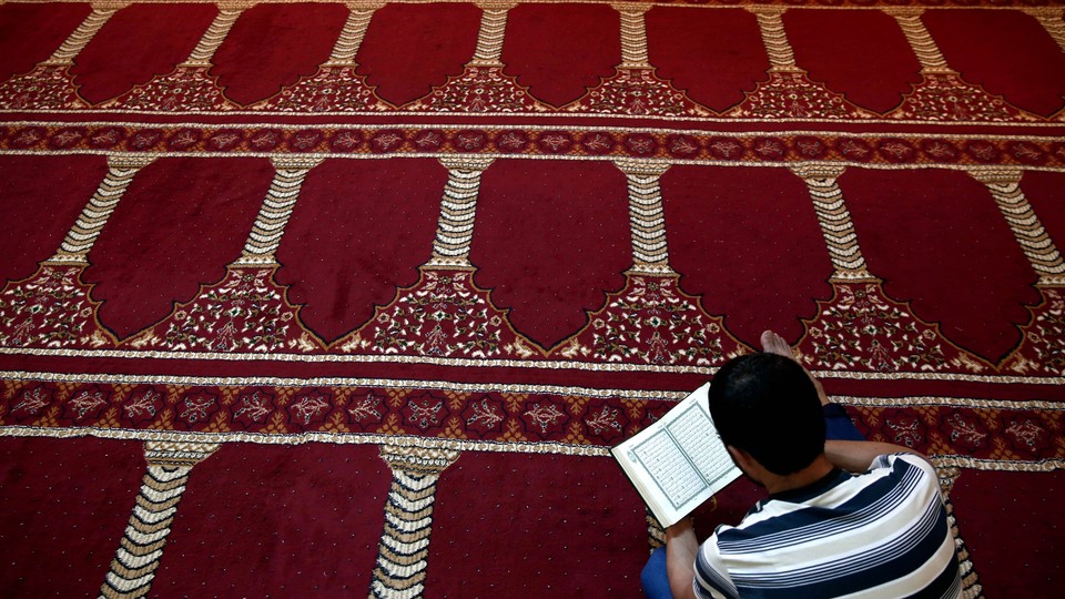 A Muslim faithful reads the Quran inside a makeshift mosque.