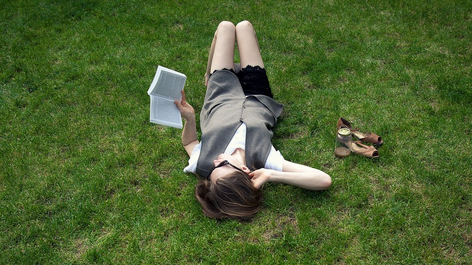 Woman reading a book in a field