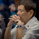 Rodrigo Duterte with a mic, mirrored so that there are two of him facing each other