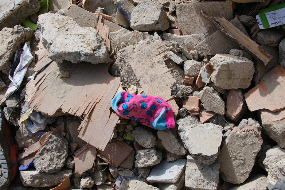 a pink sock with blue cherries sits on rubble