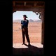 John Wayne stands alone in a doorway
