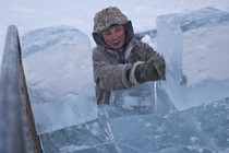 A man loads blocks of ice onto a truck outside Yakutsk