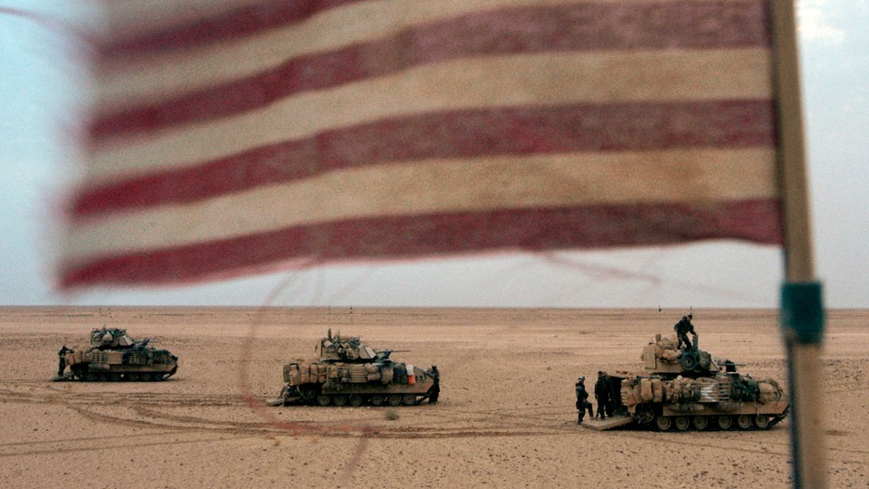 A photograph of tanks with an American flag in the foreground