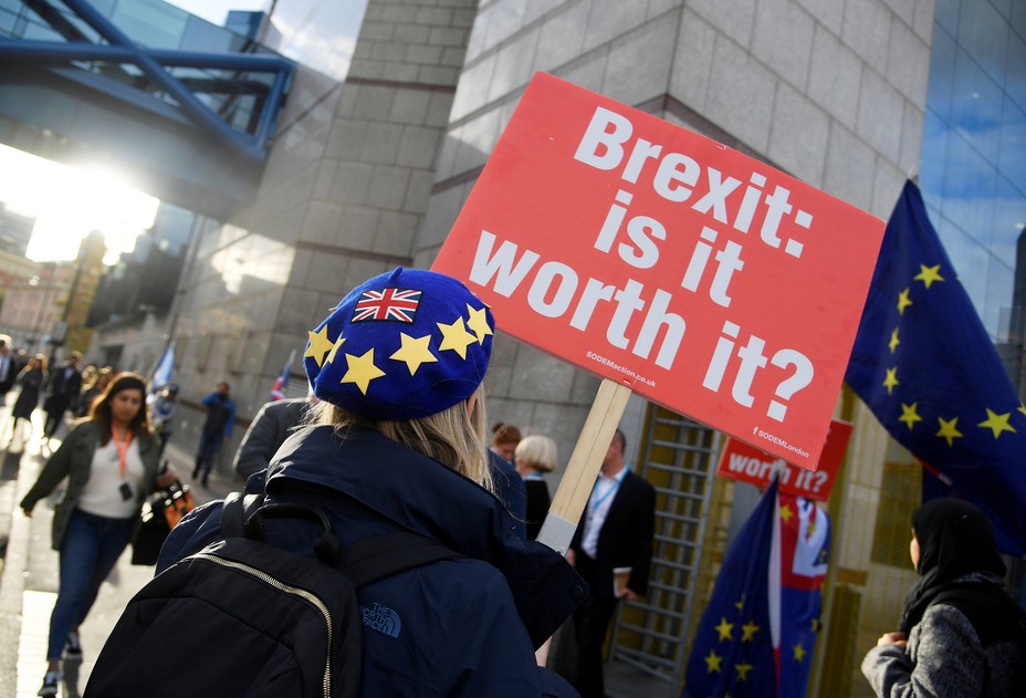 A protester holds up a placard that reads, "Brexit, Is It Worth It?"