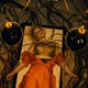 Jessie Buckley as Ida lies on a table surrounded by electrical cords, including some jutting out of her chest.