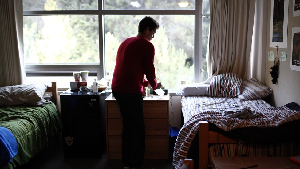 A student in his college dorm room on campus
