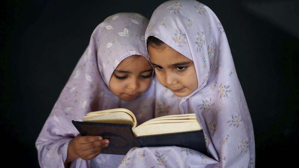 Two young girls reading the Quran