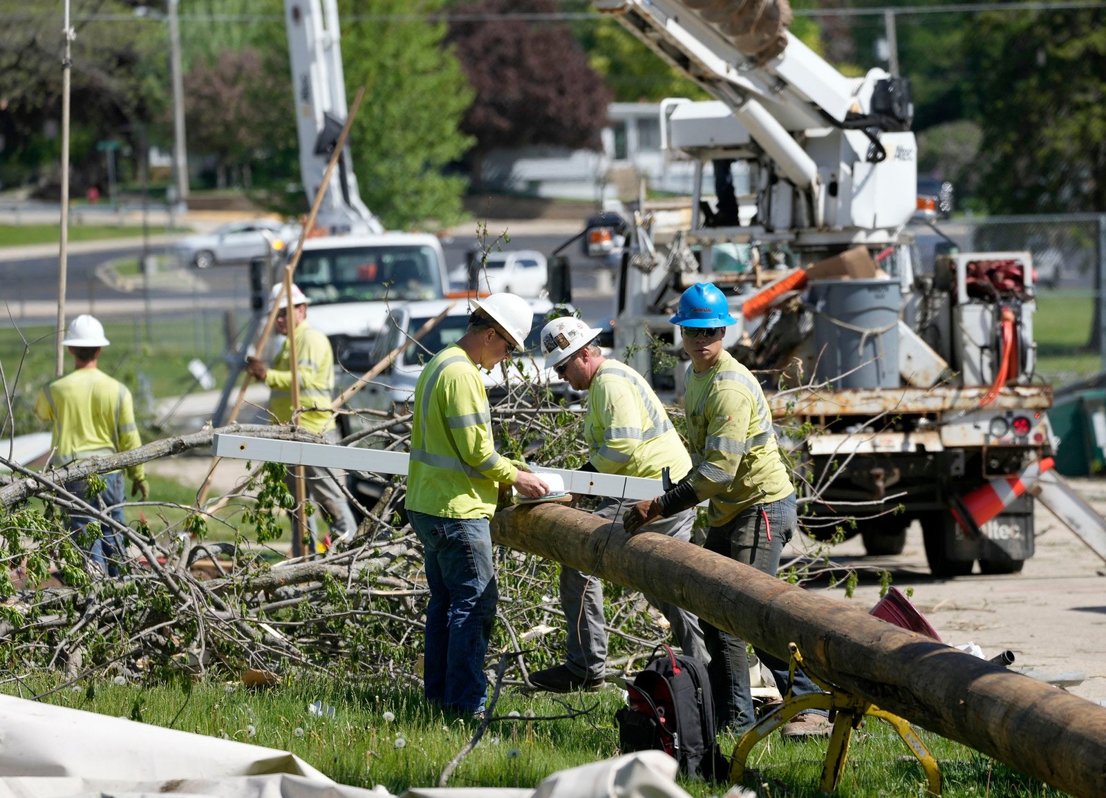 Utility workers handle a downed power pole.