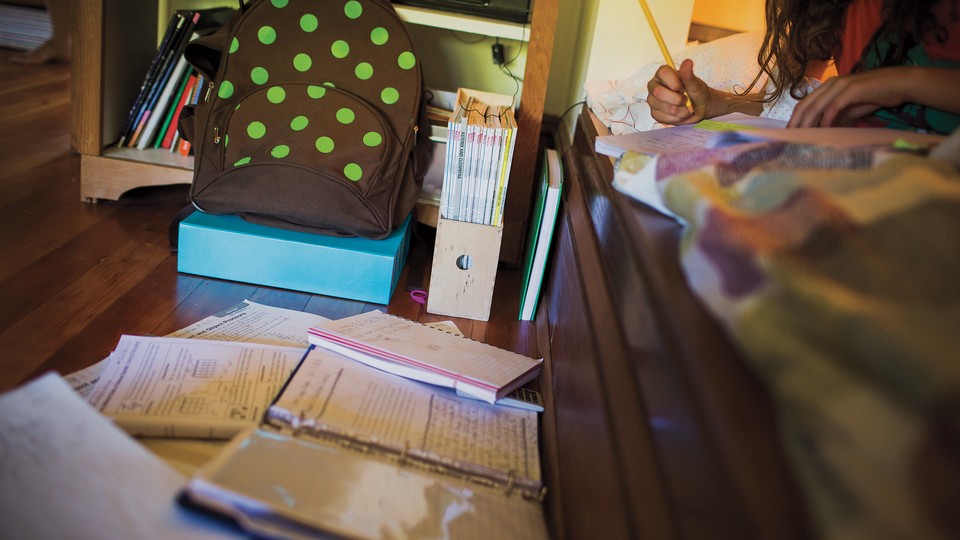 piles of homework next to a child's bed