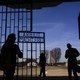 Visitors enter Sachsenhausen through a gate with the words "Arbeit macht frei" (works sets you free).