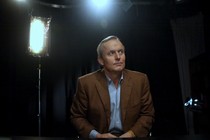 John Grisham sitting below stage lights