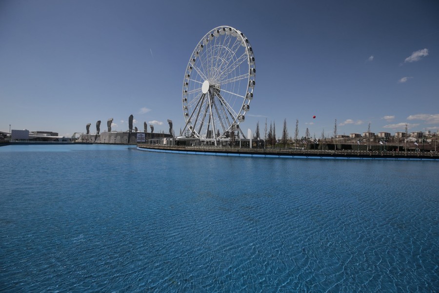 A wide view of an amusement park featuring a Ferris wheel