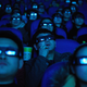 An audience wearing 3-D glasses in a movie theater