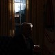 An image of Donald Trump sitting next to a window