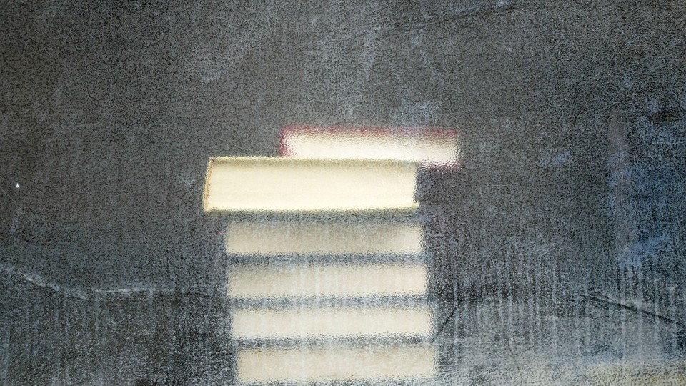 A stack of books seen through a dirty window