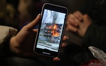 Photo of a Ukrainian refugee's smartphone, showing a video of an apartment block on fire in the city of Mykolaiv