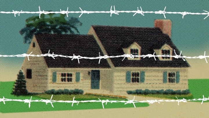 A house behind white barbed wire.