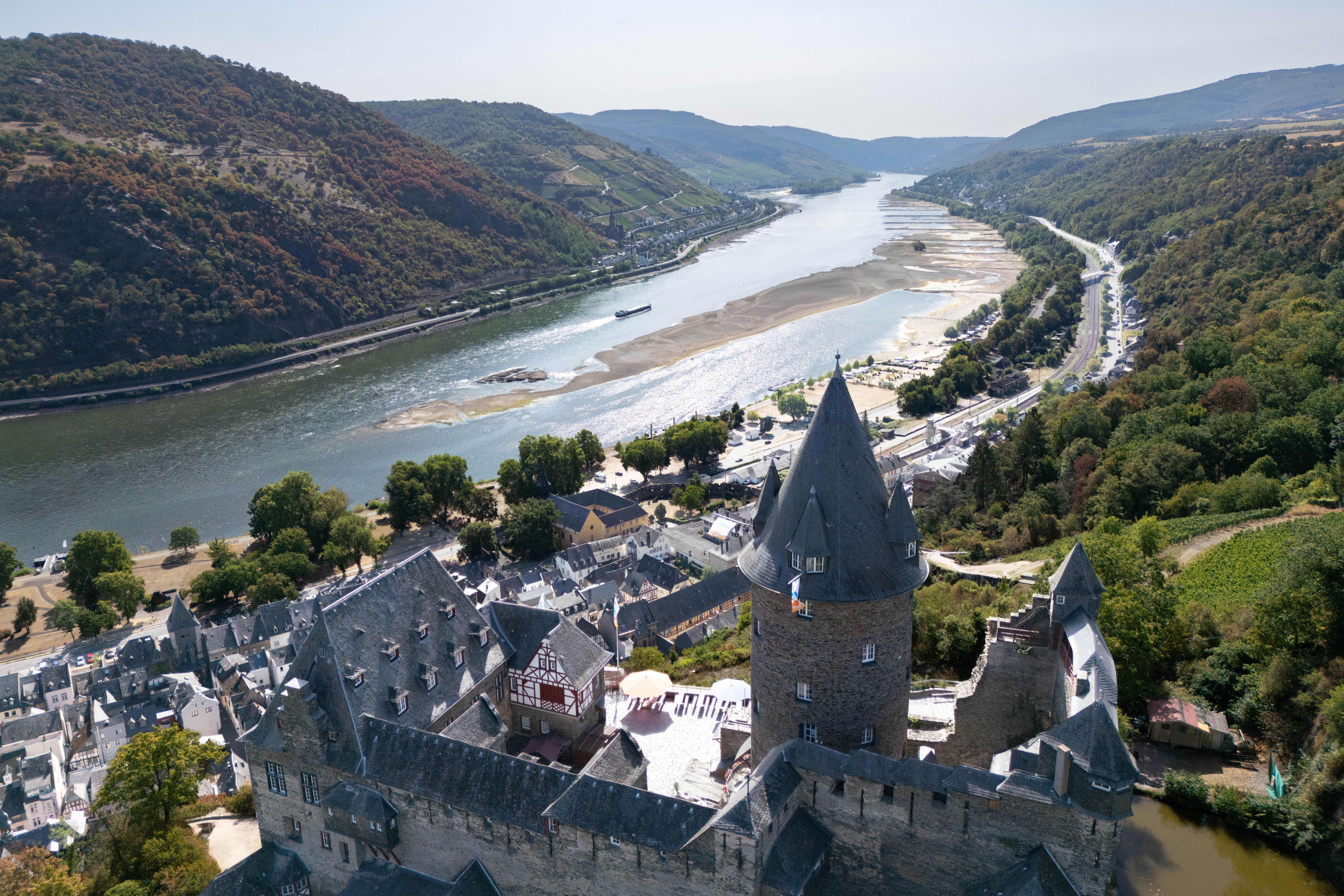 A river at low water levels, seen beneath a castle in Germany.