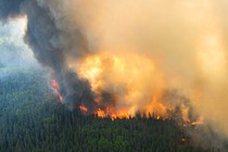 Flames reach upwards along the edge of a wildfire as seen from a Canadian Forces helicopter surveying the area near Mistissini, Quebec, Canada June 12, 2023.