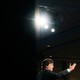 Tucker Carlson addresses an audience with a spotlight overhead.