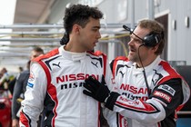 Two men on a race course in conversation, in "Gran Turismo"