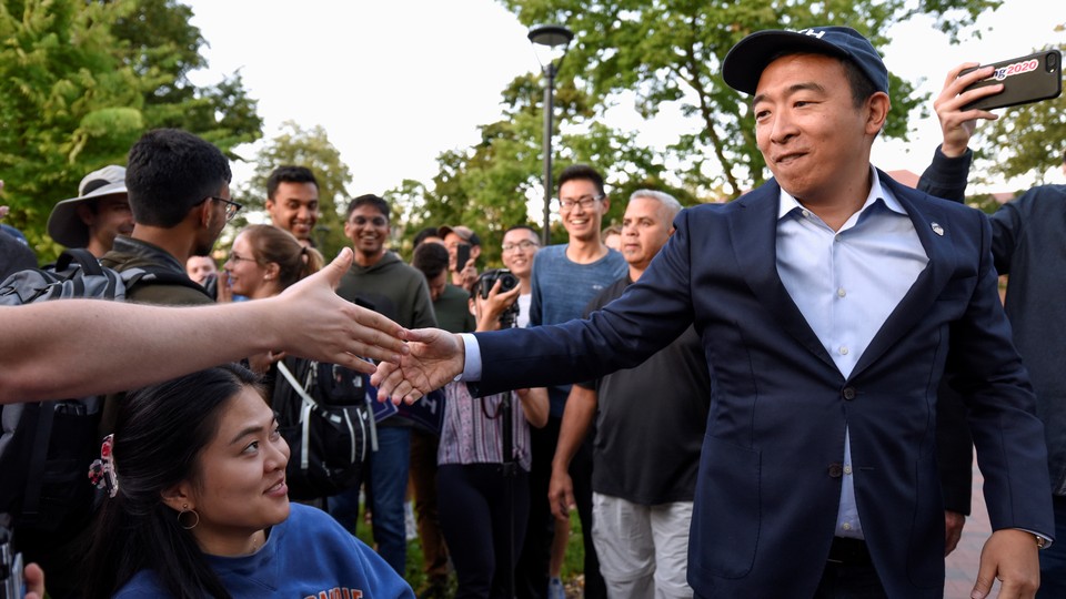 Andrew Yang shakes hands with supporters at a campaign rally.