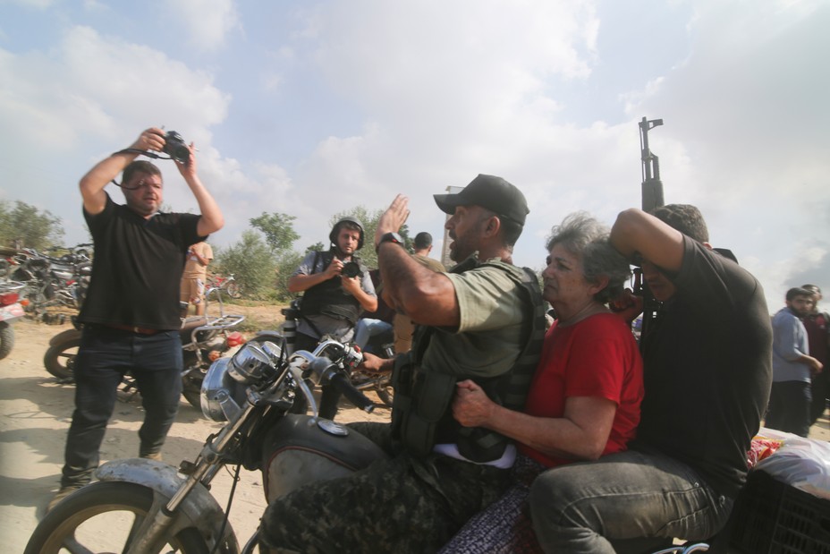 Picture of Palestinians transporting a captured Israeli civilian, center, from Kibbutz Kfar Azza into the Gaza Strip on Saturday, Oct. 7, 2023.