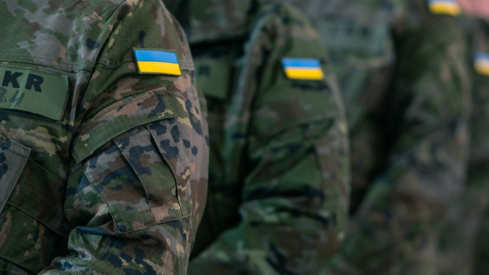 Photograph of Ukrainian flag patches on the arms of uniformed soldiers.