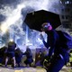 Protesters take cover behind boards during a protest in the Mong Kok area of Hong Kong.