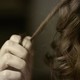 A person pulls at their curly hair with their hand.