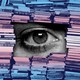 An eye peering through a wall of stacked books