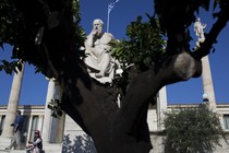 A statue of Socrates is visible behind a tree. 