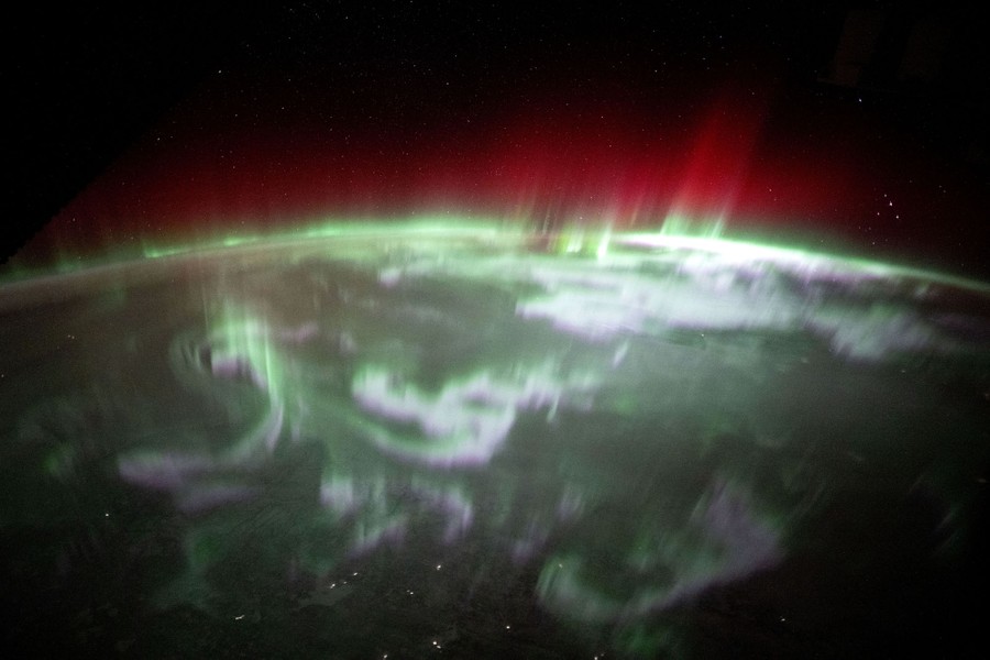 The Aurora Borealis swirls and jumps above northern Canada, seen from orbit.