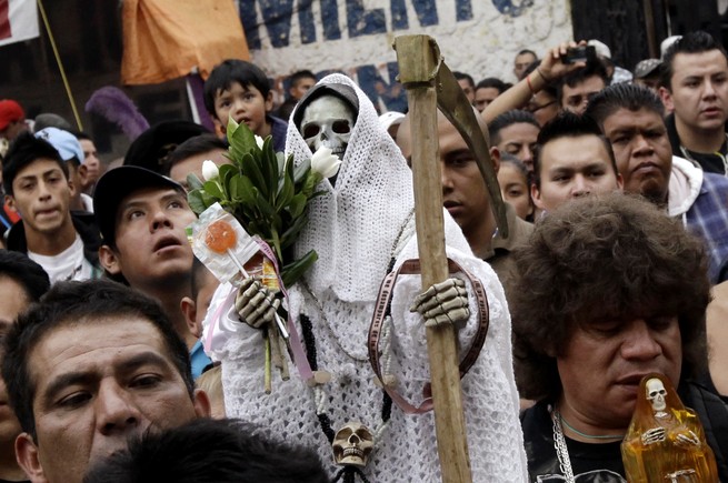 A follower holds up a Santa Muerte figurine at a celebration in Mexico City (Henry Romero / Reuters)