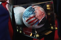 An image of a soccer ball painted with President Trump’s face and an American flag on it in a glass case titled “Ball 47”