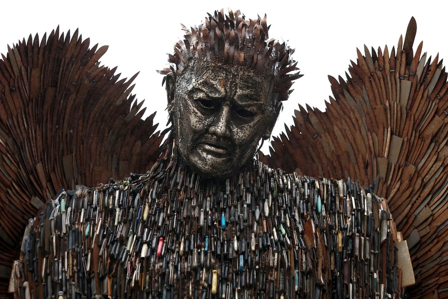 A sculpture of a pensive angel composed of thousands of knives