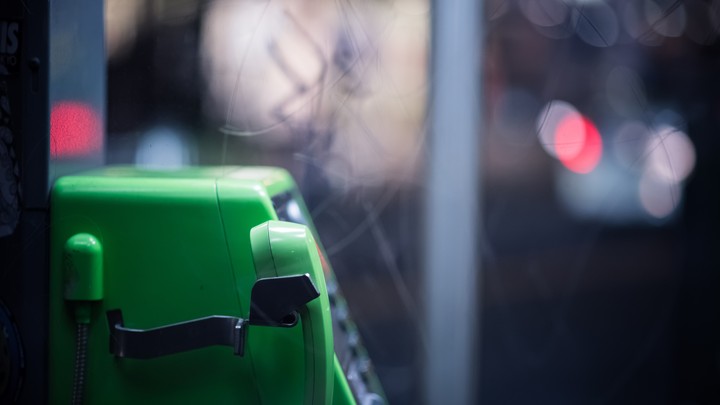 A green telephone in a phone booth