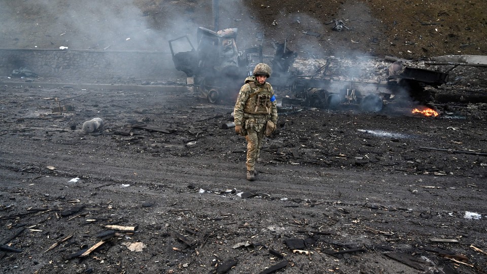 A soldier is seen walking through wreckage.