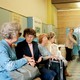 A group of older women chatting in a retro-looking laundry shop