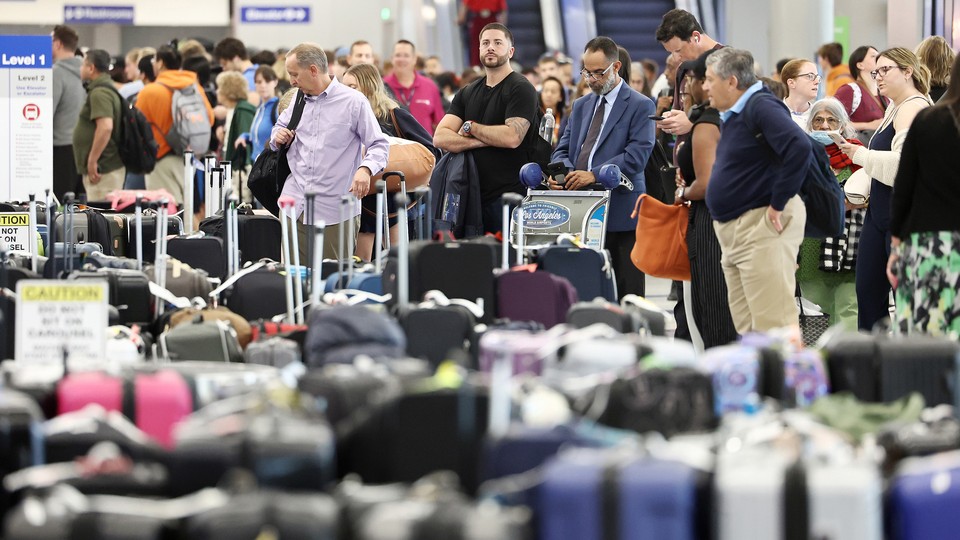 Travelers wait for their bags at Los Angeles International Airport on June 29.