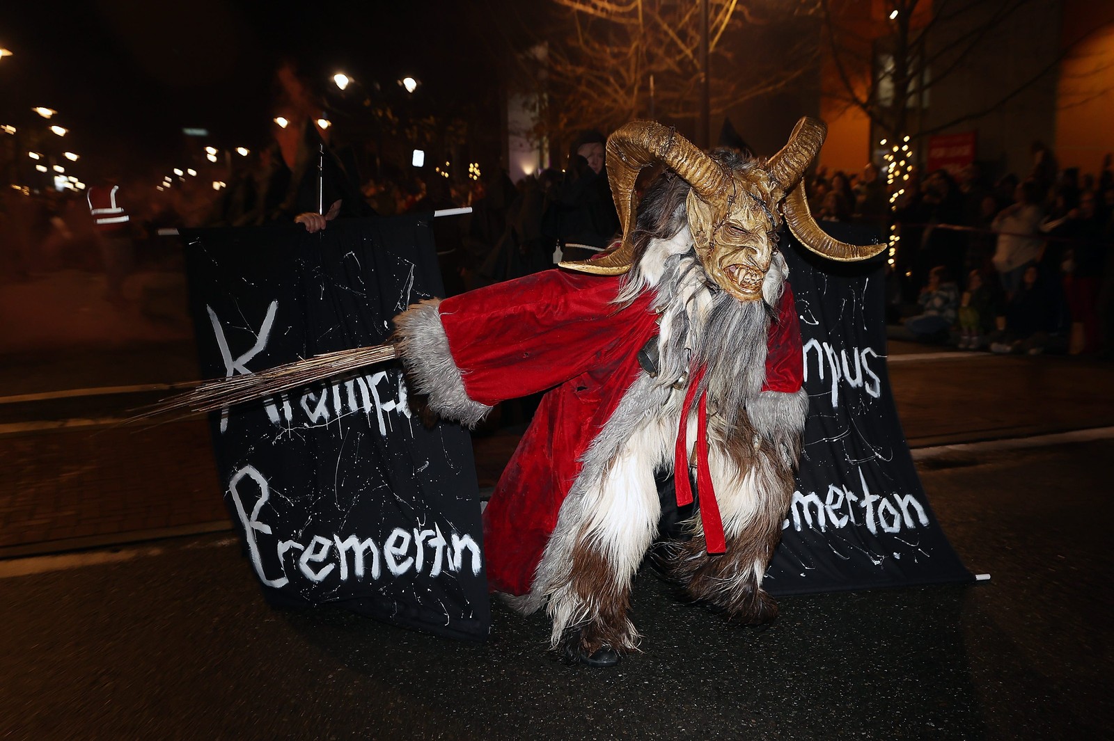 A performer wearing a Krampus costume and Santa's red, fuzzy coat takes part in a parade.