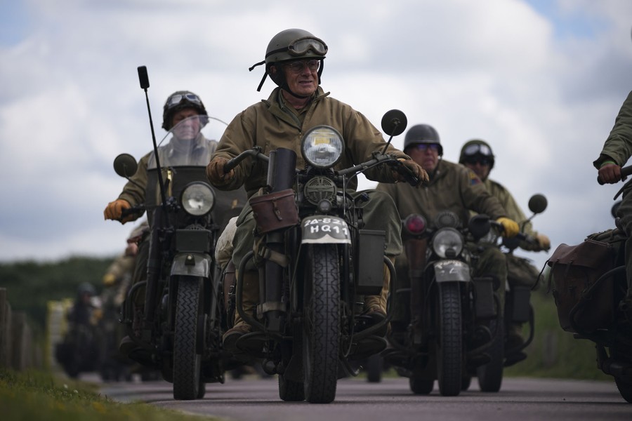 A group of WWII reenactors ride vintage U.S. Army Harley-Davidson motorbikes.