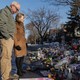An image of Minnesota Governor Tim Walz and his wife looking at the Renee Good Memorial