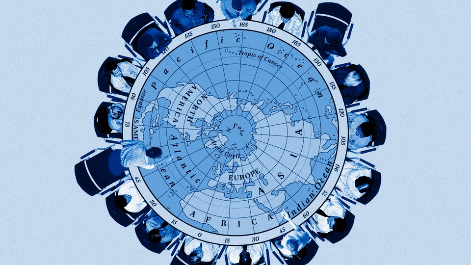 People sit around a table with a map of the Arctic on it.