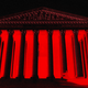 Image of the Supreme Court facade with a black background and red glow from the inside