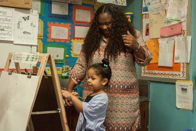 A preschool teacher at P.S. 3 in Brooklyn listens as a student explains her painting.