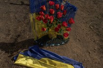 This photograph taken on March 31, 2024, shows a Ukrainian flag on a grave of a victim of the Russian strike that hit a cafe last year, at a cemetery in the village of Groza, Kharkiv region, amid the Russian invasion of Ukraine.