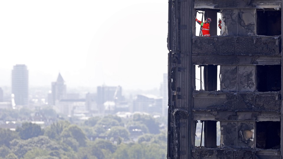 Members of the emergency services work inside the charred remains of the Grenfell Tower block on June 17, 2017.